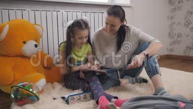 母女俩在房间里毛茸茸的地毯上读着一本儿童`书。